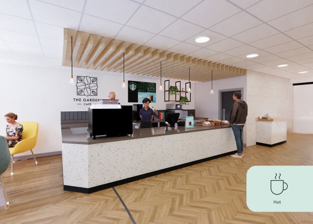 Un homme au comptoir « We Proudly Serve Starbucks » propose des boissons chaudes et froides, des spécialités de saison et bie