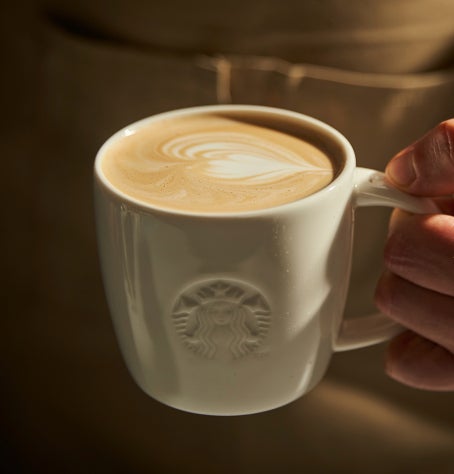 Création d’un motif de latte art dans un mug Starbucks en céramique