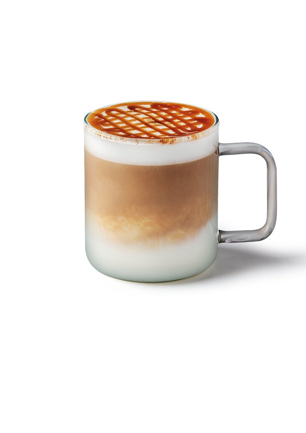 A caramel macchiato in a glass mug