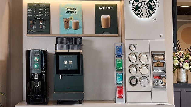 A We Proudly Serve Starbucks self-service coffee machine station