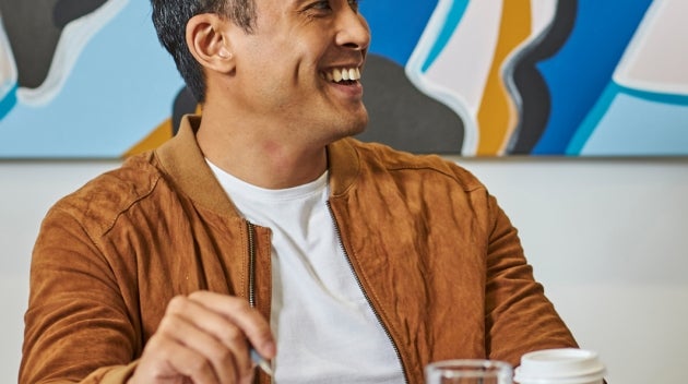 Men sitting at a conference table holding We Proudly Serve Starbucks coffee