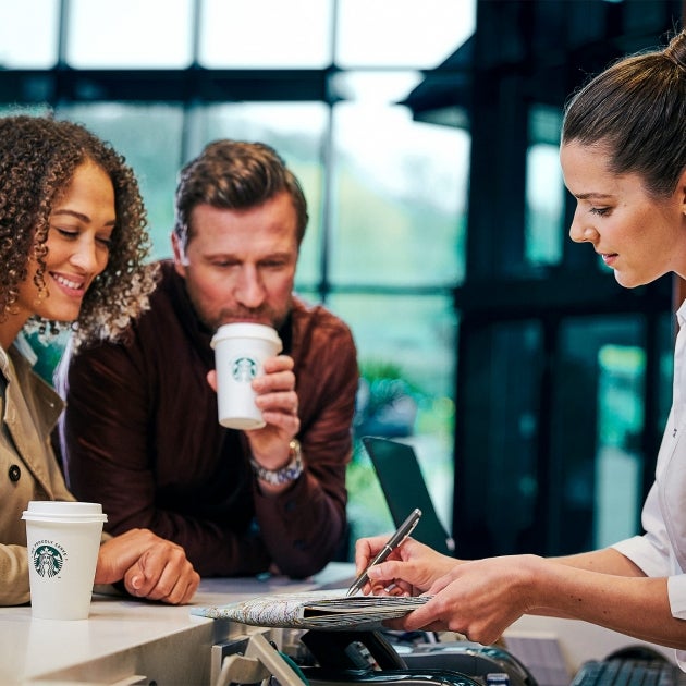 Bicchiere da caffè in cartone Starbucks su scrivania da ufficio con vista  su New York · Creative Fabrica