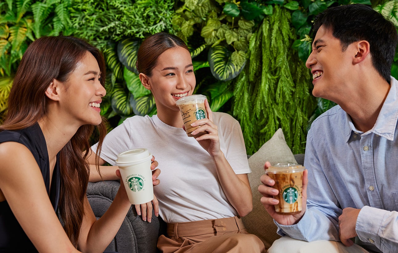 Colleagues sitting together with We Proudly Serve Starbucks cups